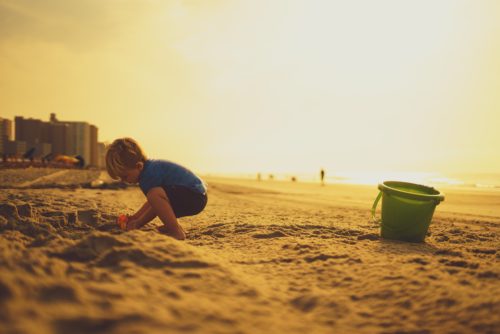 子供が砂浜で遊びに夢中になる様子