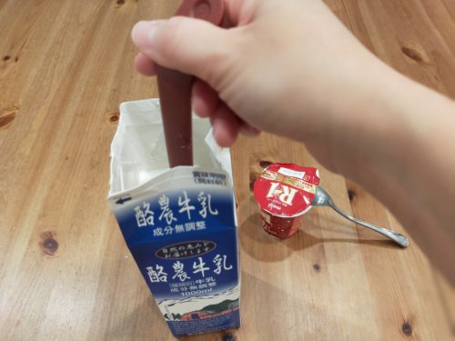 牛乳パックにマドラーを入れて混ぜている