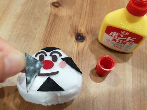 フェルトにボンドをつけておむすびまんの顔を作る