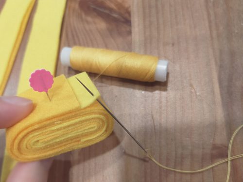 巻いたフェルトを糸で縫う