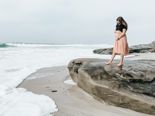 海辺を歩く妊婦