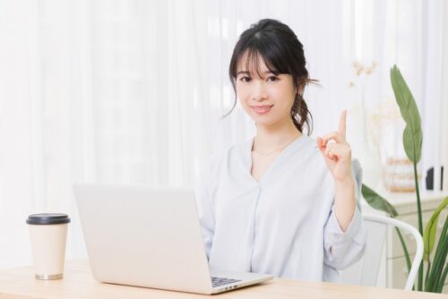 パソコンを広げて指を指している女性